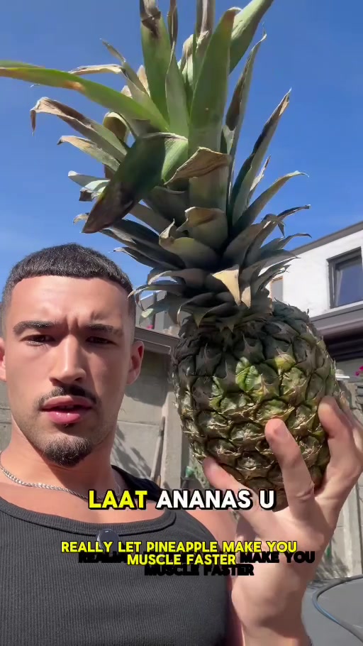 Yûnes outdoors holding a pineapple